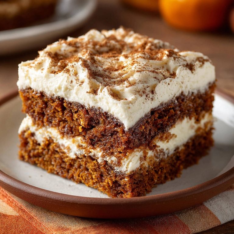Saftiger Gewürzkuchen mit Frischkäse-Creme zeigt einen köstlichen Querschnitt mit cremiger Frischkäse-Schicht und Zimt-Topping.