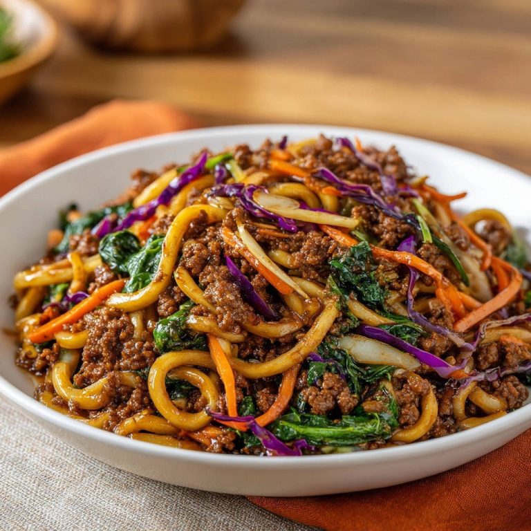 Würzige Udon-Pfanne mit Rinderhack in einer weißen Schüssel von oben gesehen, mit Nudeln, Hackfleisch und Gemüse.