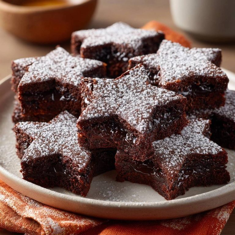 Sternförmige Schoko-Lava-Brownies mit köstlicher Schokoladenfüllung, im Anschnitt gezeigt, auf einem Teller serviert und mit Puderzucker bestäubt.