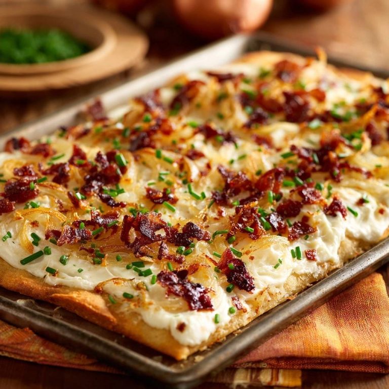 Kartoffel-Speck-Zwiebel-Blech, serviert auf einem Blech, mit knusprigem Speck und frischen Schnittlauch-Streuseln garniert.