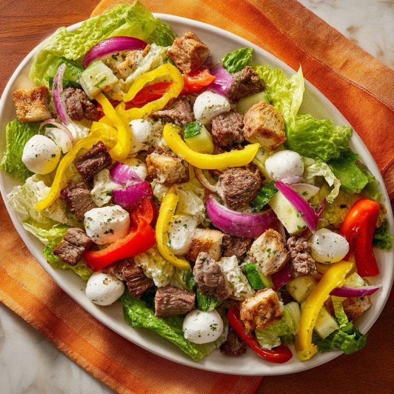 Knackiger Rindfleischsalat mit Mozzarella und Paprika, serviert in einer ovalen Schüssel, mit einer Vielzahl von Zutaten von oben gesehen.