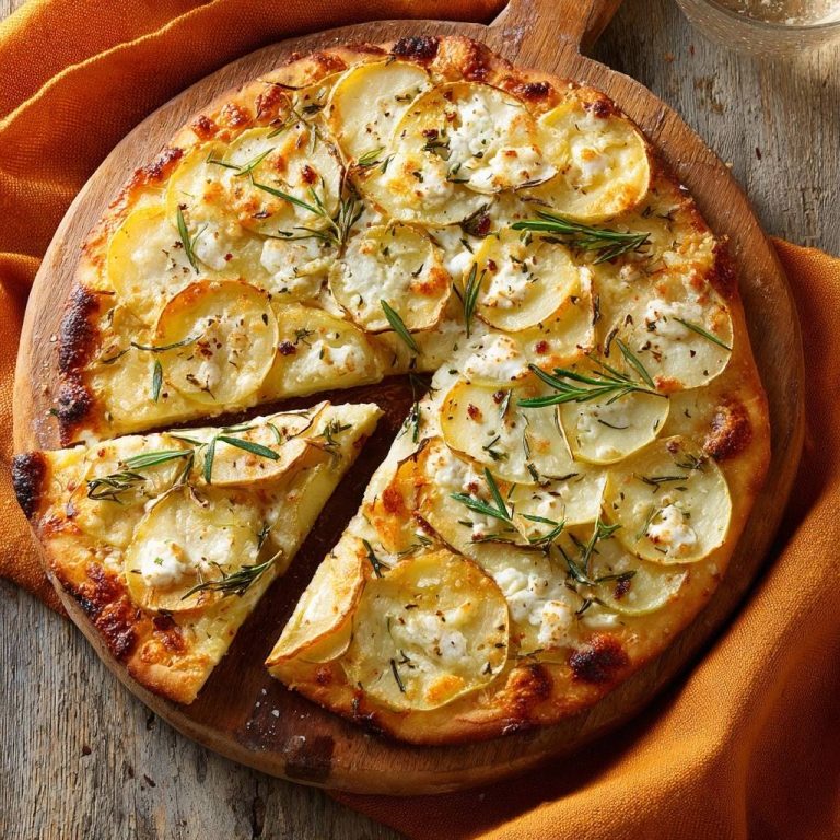 Knusprige Kartoffel-Feta-Pizza mit Rosmarin von oben gesehen, mit einem Stück angeschnitten, das die Kartoffel- und Feta-Beläge zeigt.