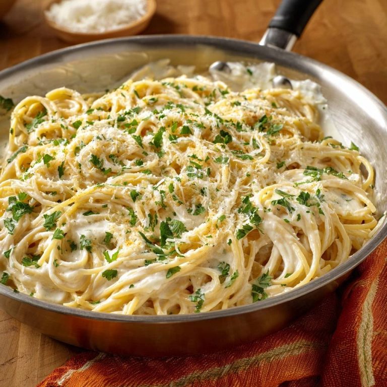 Cremige Linguine mit Parmesan und Petersilie, serviert in einer Pfanne, draufsicht mit frischer Petersilie und geriebenem Parmesan.