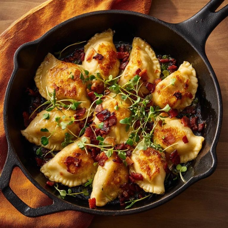 Knusprige Pierogi mit Speck, serviert in einer gusseisernen Pfanne, garniert mit frischer Kresse und knusprigem Speck.