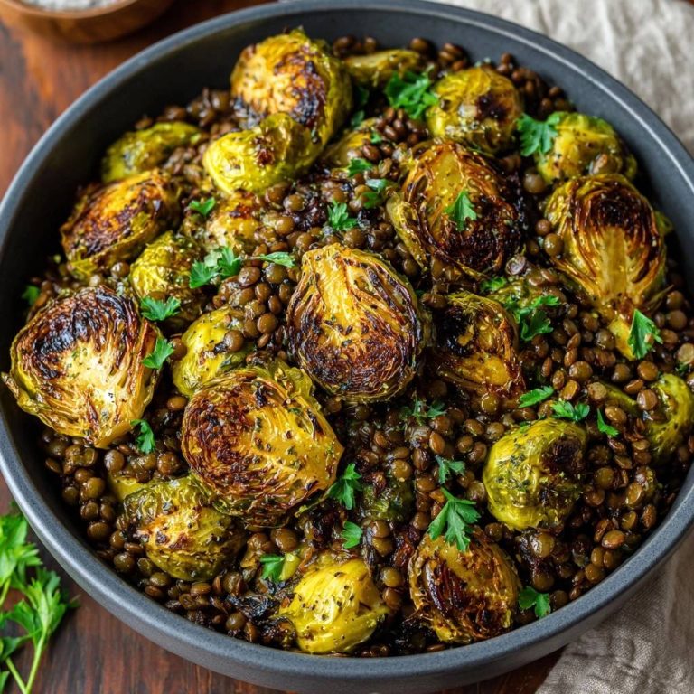 Knuspriger Rosenkohl mit Linsen in einer Schüssel, serviert von oben. Dieses Gericht ist mit frischer Petersilie garniert.