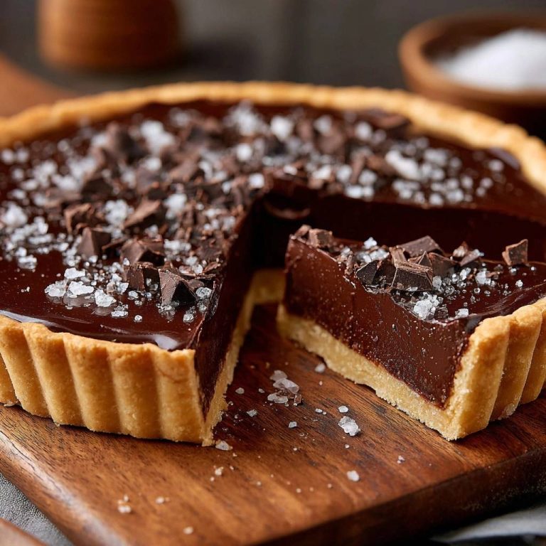 Meersalz-Schokoladen-Tarte im Nahaufnahme-Querschnitt, der die cremige Schokoladenfüllung und den knusprigen Boden zeigt.