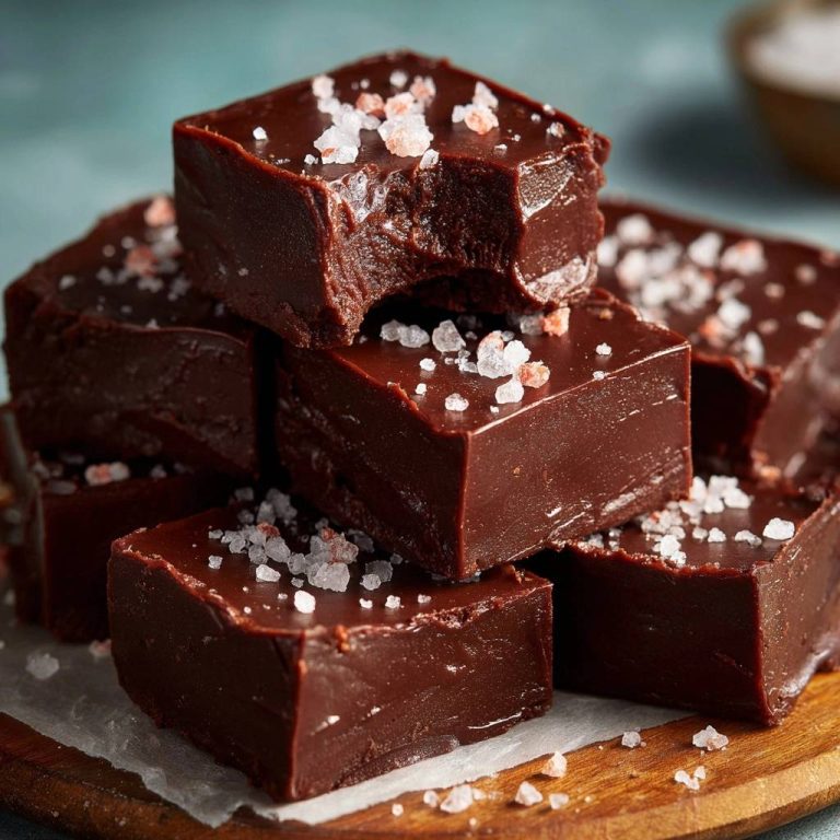Cremiges Meersalz-Schokoladen-Fudge, das perfekte Rezept, präsentiert mit einem Stück, das angeschnitten ist, um die cremige Textur zu zeigen.