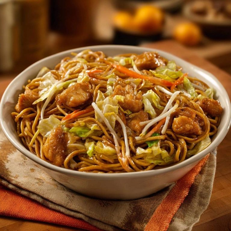 Hähnchen Chow Mein wird in einer grossen Schüssel serviert, garniert mit knackigem Gemüse und saftigem Hähnchen.