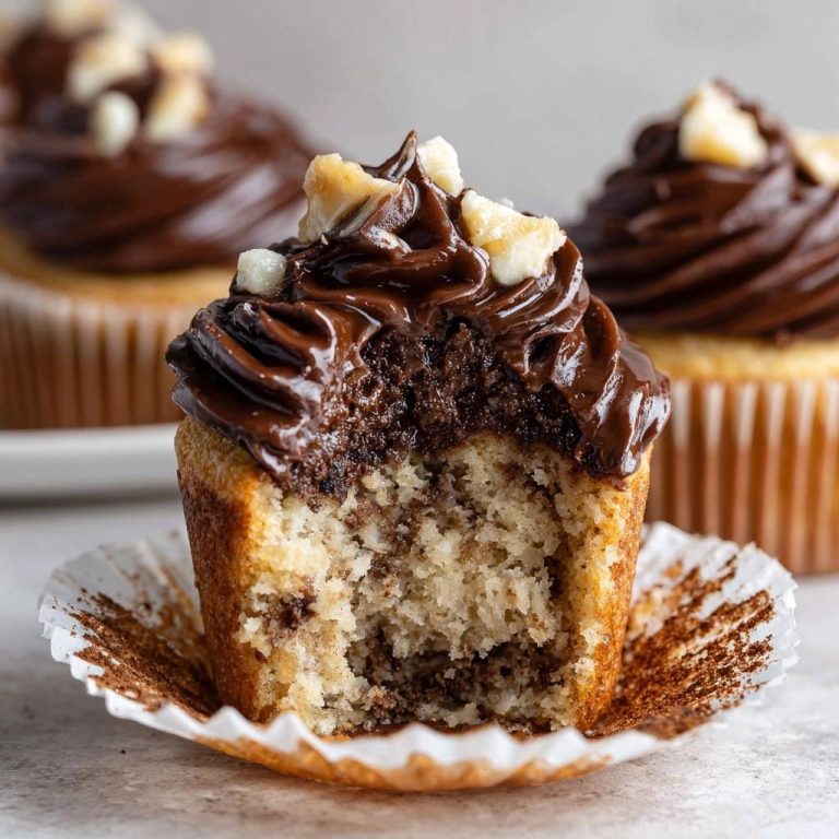 Marmor-Cupcakes mit Schokohaube zeigen hier einen köstlichen Querschnitt, der die saftige Textur des Kuchens mit der Schokoladencreme kombiniert.
