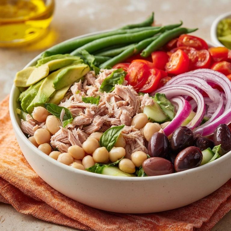 Mediterrane Thunfisch-Bowl mit Kichererbsen & Avocado in einer Schüssel, serviert mit frischen Zutaten wie Tomaten und Oliven.