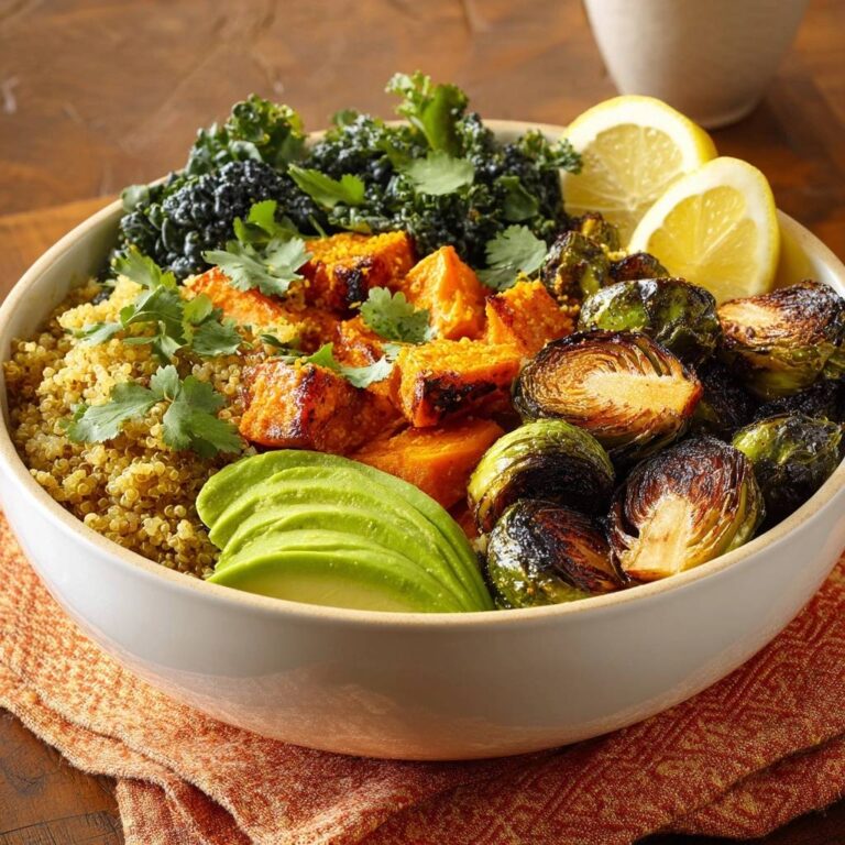 Geröstete Quinoa-Bowl mit Süßkartoffeln und Rosenkohl in einer Schüssel, von oben betrachtet, mit Avocado und frischen Kräutern garniert.